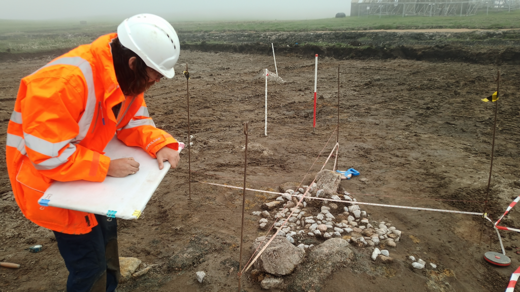 Member of the AOC Archaeology team Craig Stewart assessing the find on site at SaxaVord Spaceport.